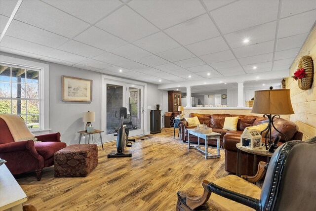 living area with wood finished floors, recessed lighting, and a drop ceiling
