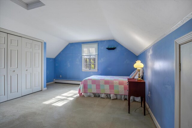 carpeted bedroom with baseboard heating, vaulted ceiling, a closet, and baseboards