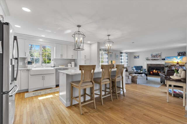 kitchen with appliances with stainless steel finishes, a sink, light wood-style floors, recessed lighting, and light countertops