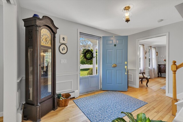 entryway with wood-type flooring, baseboard heating, and a baseboard radiator