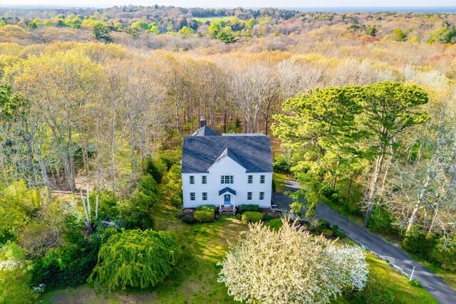 aerial view of property and surrounding area with a heavily wooded area