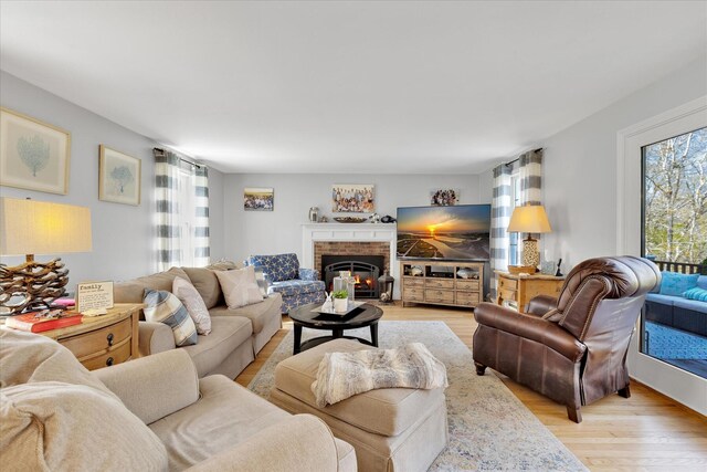 living area with healthy amount of natural light, light wood finished floors, and a fireplace