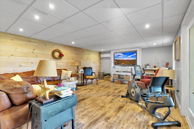 living area featuring wood finished floors, wood walls, recessed lighting, and a drop ceiling