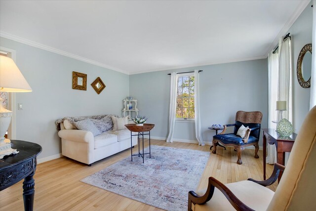 living room featuring wood finished floors, baseboards, and crown molding