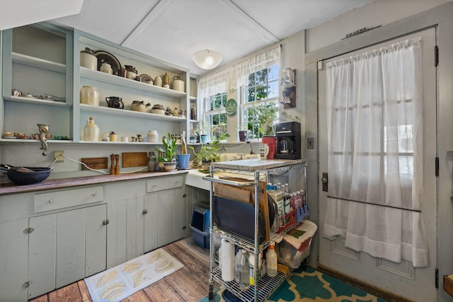 kitchen featuring wood finished floors, a wood stove, and light countertops