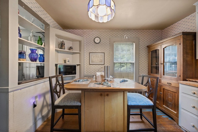 dining space featuring wallpapered walls and dark wood-style floors