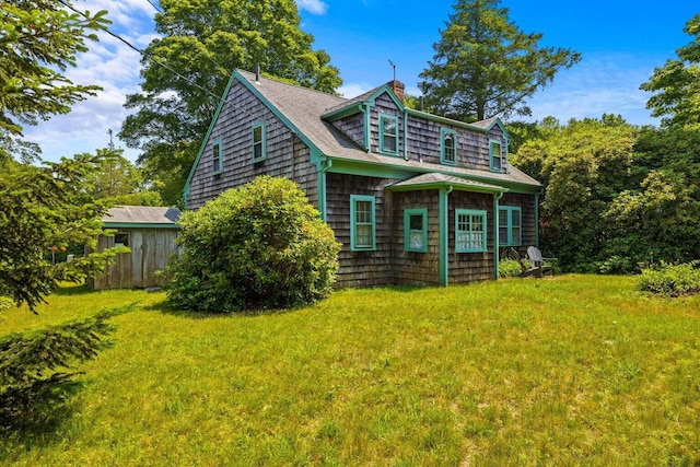 rear view of house with a chimney and a yard