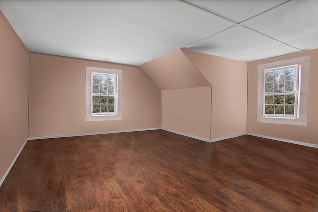 bonus room with wood finished floors, baseboards, and vaulted ceiling