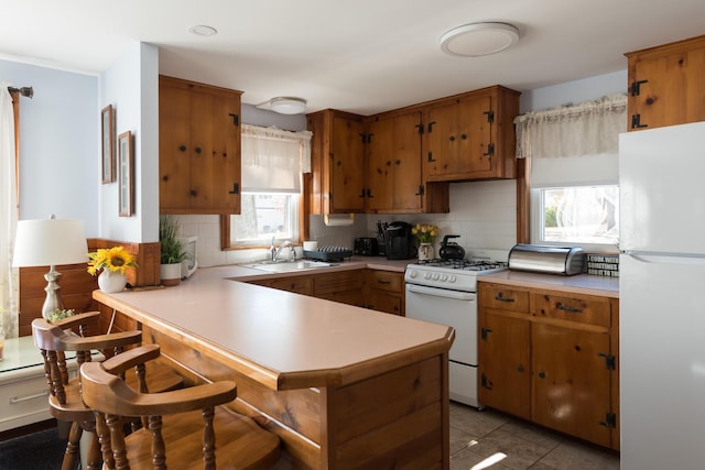 2 Naushon Rd, Mashpee, MA 02649 - kitchen featuring white appliances, a sink, light countertops, brown cabinets, and a peninsula