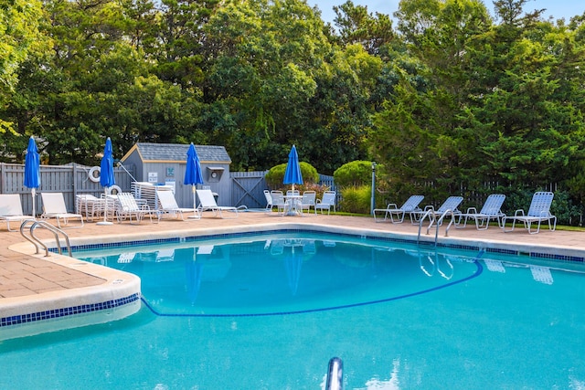 community pool with fence and a patio area