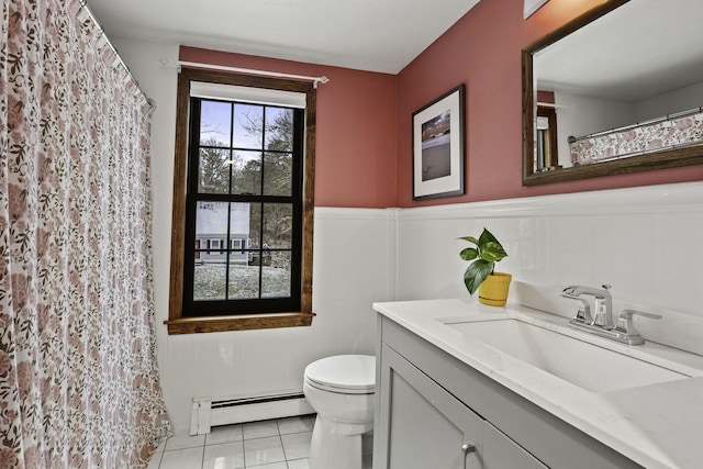 full bathroom with a baseboard radiator, tile patterned flooring, toilet, a wainscoted wall, and vanity