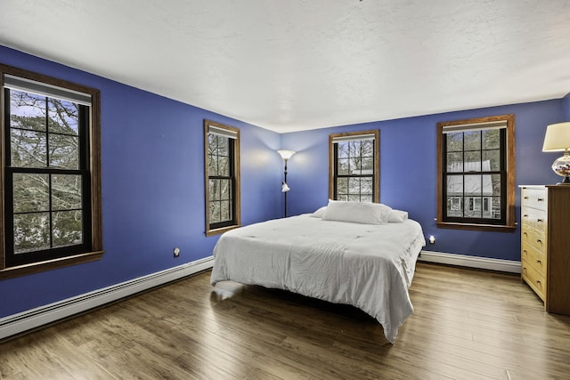 bedroom featuring wood-type flooring and baseboard heating