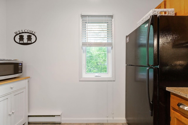 288 Fletcher Ln, Brewster, MA 02631 - kitchen with freestanding refrigerator, stainless steel microwave, a baseboard radiator, light countertops, and white cabinetry
