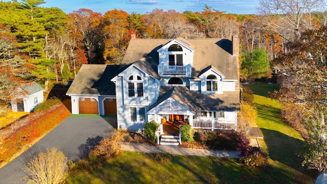 view of front of home with covered porch, a garage, and a balcony