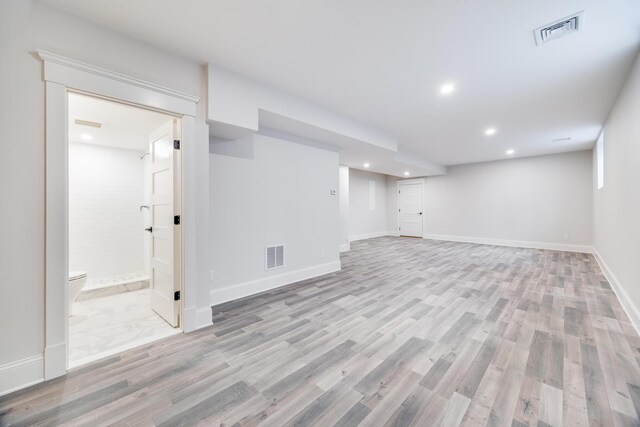 basement with light hardwood / wood-style floors