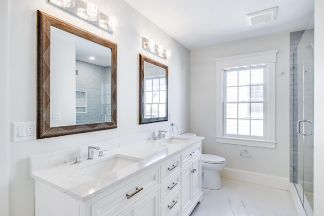 bathroom with vanity, toilet, and a shower with door