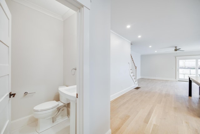 bathroom featuring ceiling fan, wood-type flooring, ornamental molding, and toilet