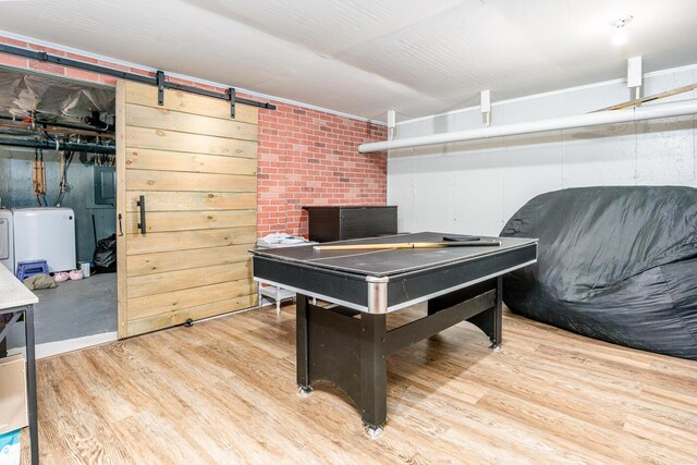 game room featuring wood-type flooring, separate washer and dryer, brick wall, and wood walls