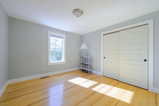 unfurnished bedroom with light hardwood / wood-style floors and a closet