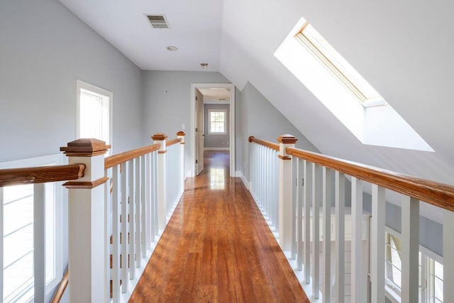 hall featuring wood-type flooring and lofted ceiling with skylight