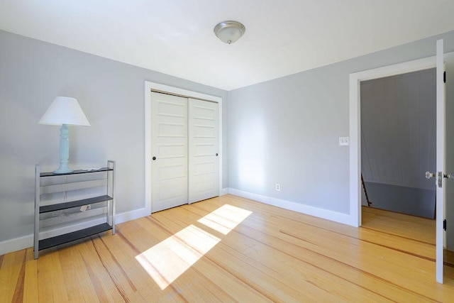 unfurnished bedroom featuring wood-type flooring and a closet