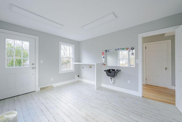 laundry area featuring light hardwood / wood-style floors and electric dryer hookup