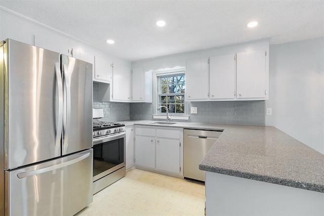 kitchen with sink, white cabinetry, appliances with stainless steel finishes, and a textured ceiling