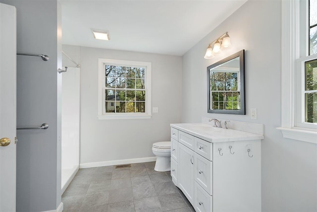 bathroom featuring vanity, toilet, and a shower