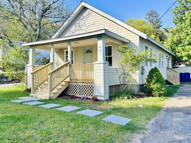bungalow-style house with a porch, a front yard, and stairs