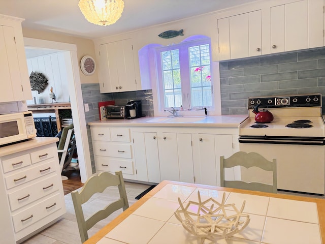 69 Captain Chase Rd, Dennis Port, MA 02639 - kitchen featuring white appliances, a sink, decorative backsplash, light countertops, and white cabinets