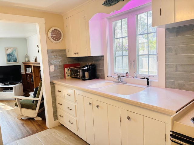 69 Captain Chase Rd, Dennis Port, MA 02639 - kitchen featuring a sink, light countertops, white cabinets, and backsplash