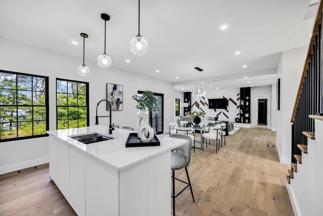 2 Buttercup Ln, South Yarmouth, MA 02664 - kitchen with recessed lighting, an island with sink, light wood-style flooring, pendant lighting, and white cabinets
