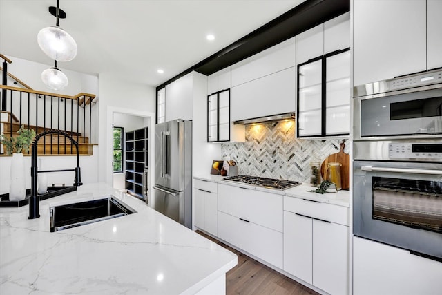 2 Buttercup Ln, South Yarmouth, MA 02664 - kitchen featuring stainless steel appliances, decorative backsplash, hanging light fixtures, white cabinetry, and light stone counters