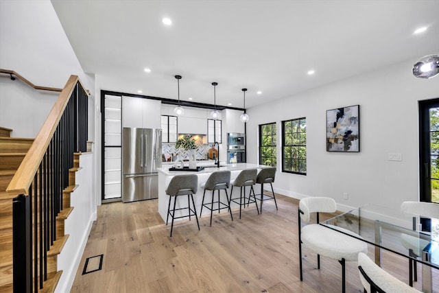 2 Buttercup Ln, South Yarmouth, MA 02664 - kitchen with stainless steel appliances, white cabinets, a kitchen bar, a center island with sink, and recessed lighting