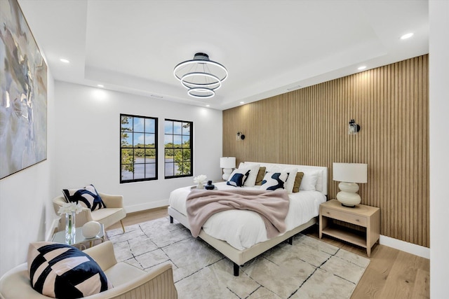 2 Buttercup Ln, South Yarmouth, MA 02664 - bedroom with light wood-style floors, recessed lighting, an accent wall, a tray ceiling, and wood walls