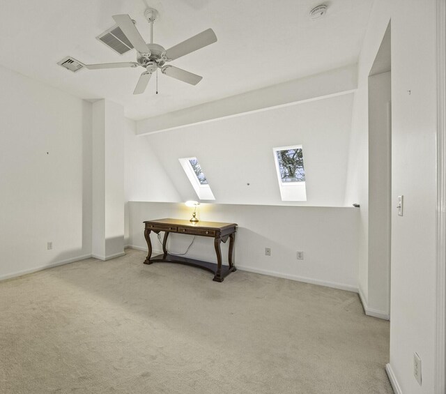 bonus room with ceiling fan, lofted ceiling with skylight, and light carpet