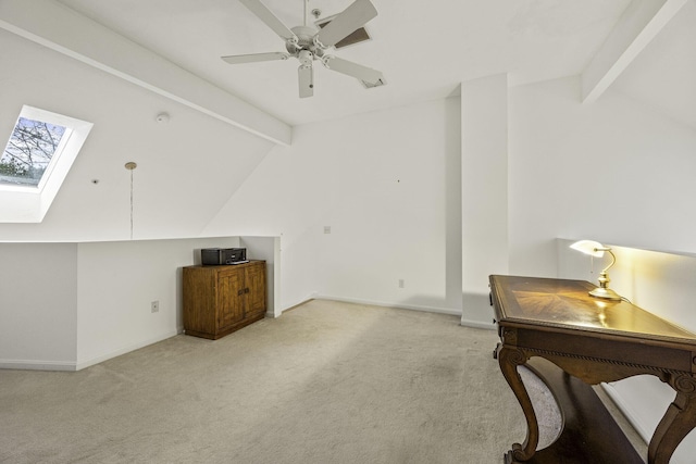 interior space featuring ceiling fan, lofted ceiling with skylight, and light carpet