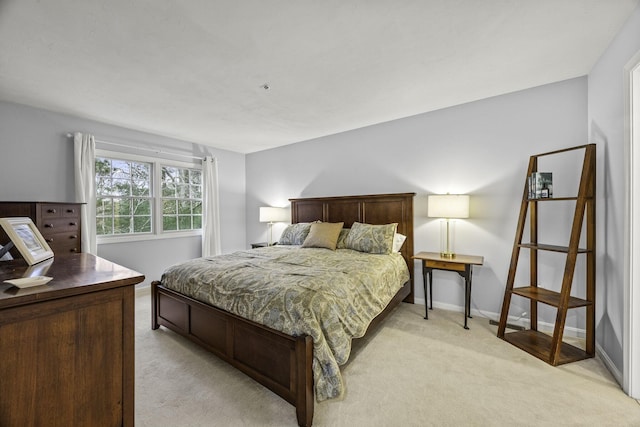 bedroom featuring light colored carpet and baseboards