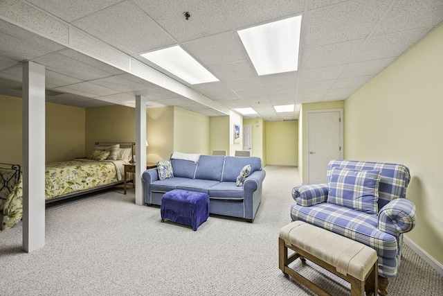 living room featuring baseboards, a paneled ceiling, and carpet