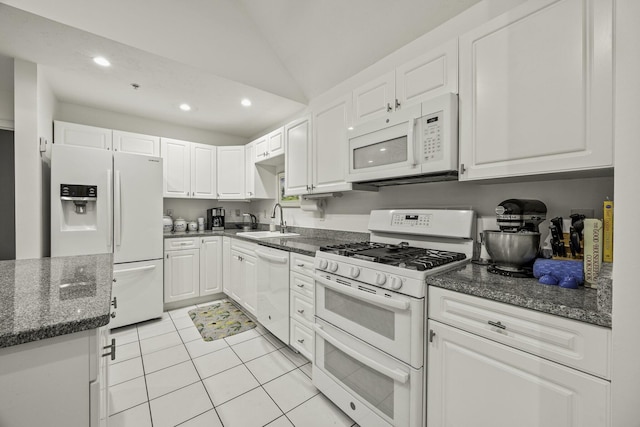 kitchen with white appliances, white cabinets, light tile patterned floors, and a sink