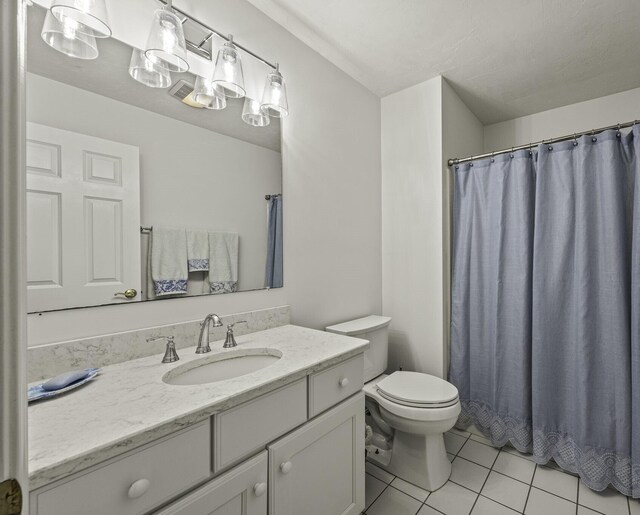 bathroom featuring tile patterned floors, vanity, and toilet