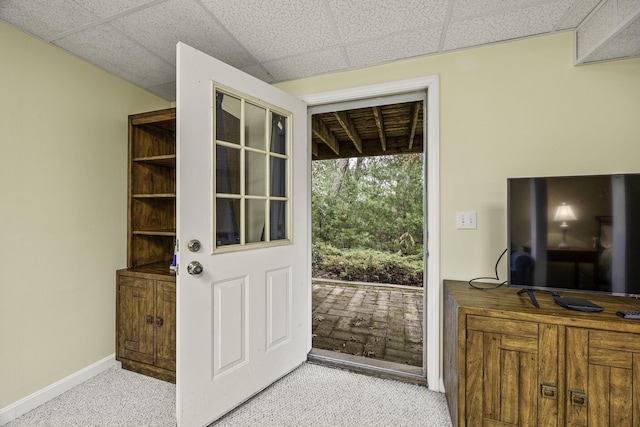 doorway to outside featuring light colored carpet and a paneled ceiling