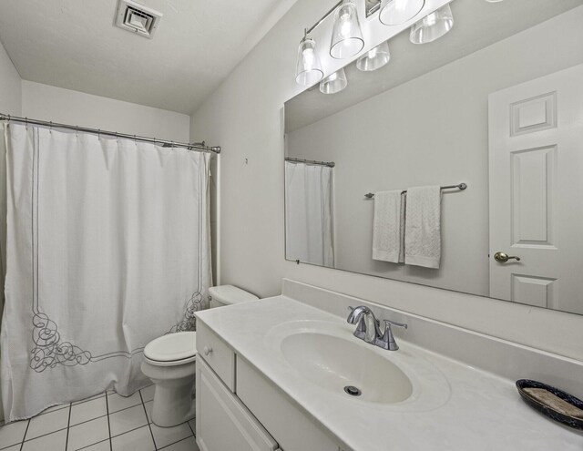 bathroom with visible vents, a shower with curtain, toilet, tile patterned flooring, and vanity