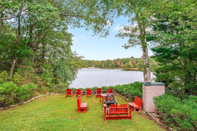 view of yard featuring a forest view and a water view