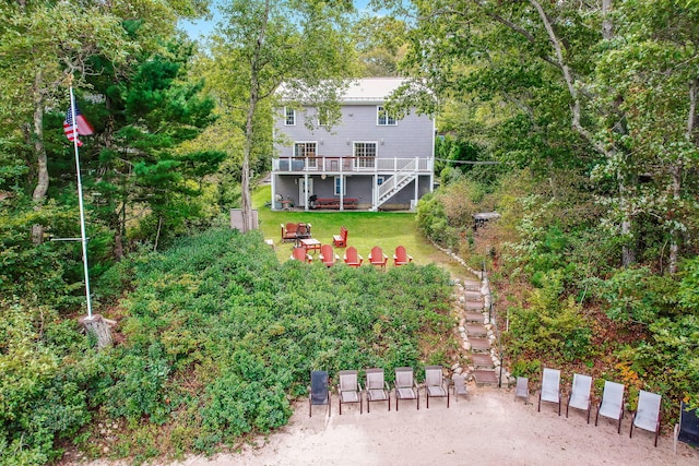 exterior space featuring a wooden deck, a lawn, and stairway