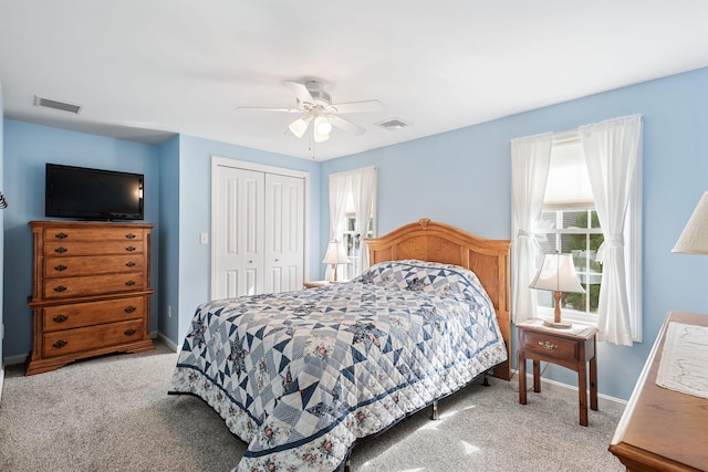 bedroom with baseboards, visible vents, carpet, a ceiling fan, and a closet