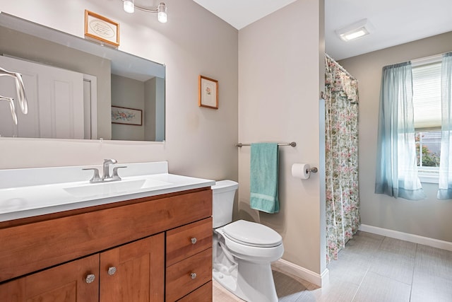 bathroom with toilet, vanity, a shower with shower curtain, and baseboards