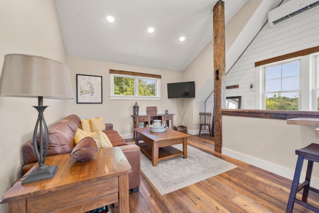 living room featuring a wall unit AC, wood finished floors, baseboards, recessed lighting, and high vaulted ceiling