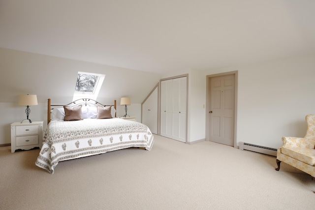 carpeted bedroom featuring vaulted ceiling with skylight, baseboard heating, and a closet