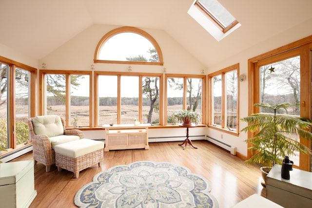 sunroom / solarium featuring lofted ceiling with skylight and a baseboard heating unit